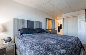 York apartment for rent - A bedroom with a bed, nightstand, and lamp.