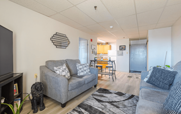 York apartment for rent - A living room with a grey couch and a television.