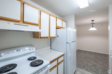 South Riding apartment for rent - A kitchen with a white stove top oven and a white refrigerator.