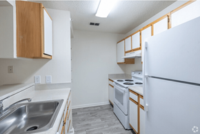 South Riding apartment for rent - A kitchen with white appliances and wooden cabinets.