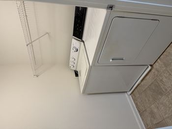 A white wall with a white door and a white cabinet with a black handle
