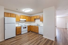 Fredericksburg townhouse for rent - A kitchen with wooden cabinets and white appliances.at The Village at England Run, Fredericksburg, VA