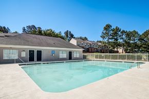 Rock Hill apartment for rent - A swimming pool in front of a building with a blue sign.