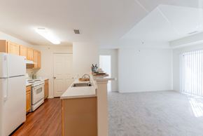 Woodbridge apartment for rent - A kitchen with white appliances and wooden cabinets.at Woodwind Villa Apartments, Woodbridge, VA