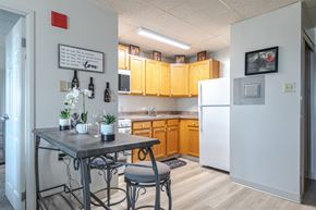 York apartment for rent - A kitchen with a table and chairs in front of a refrigerator.