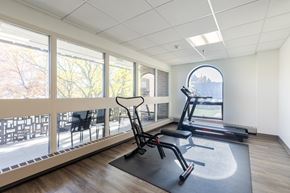 York apartment for rent - A gym room with a treadmill, exercise bike, and a chair.