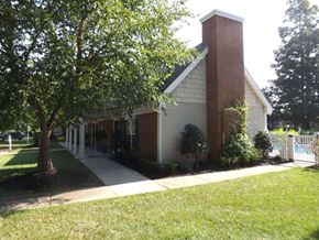 Chester apartment for rent - A small church with a red brick chimney is surrounded by a white picket fence and green trees.