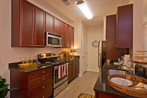 Dumfries apartment for rent - A kitchen with brown cabinets and a black counter top.