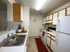 South Riding apartment for rent - A kitchen with white cabinets and a white fridge.