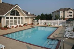 South Riding apartment for rent - A swimming pool surrounded by a white fence and chairs.