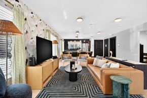 St. Petersburg apartment for rent - A modern living room with a large sofa, a coffee table, and a television.