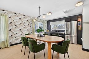 St. Petersburg apartment for rent - A modern dining room with a round table and green chairs.