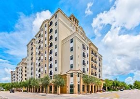 Miami apartment for rent - A large, modern building with a beige facade and a red roof.