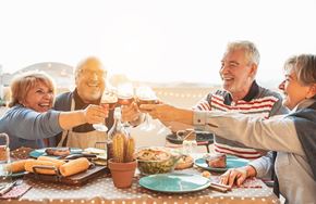 Bradenton apartment for rent - A group of people toasting with wine glasses at a dinner table.