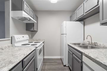 Greenville apartment for rent - A kitchen with a white stove and a white refrigerator.
