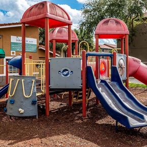 Miami apartment for rent - A playground with a blue slide and a red structure.