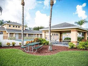 Florida City apartment for rent - A building with a green lawn in front and a picnic table in the middle.