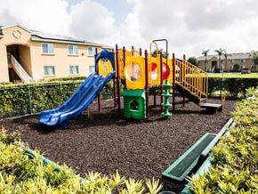 Florida City apartment for rent - A playground with a blue slide and a yellow and red structure.