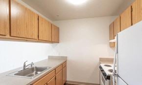 Woodbridge apartment for rent - A kitchen with wooden cabinets and a white refrigerator.at River Run Senior Apartments, Virginia, 22193