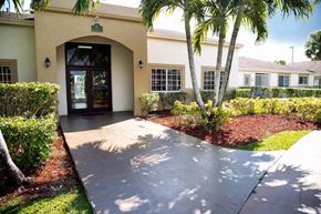 Homestead apartment for rent - A building with a palm tree in front of it.
