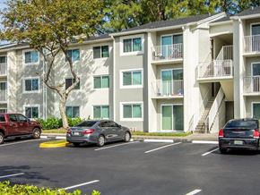 Fort Lauderdale apartment for rent - A parking lot in front of a multi-story apartment building with cars parked in the spaces.