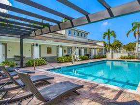 Fort Lauderdale apartment for rent - A pool with lounge chairs and a building in the background.