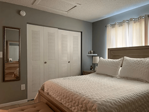 Homestead apartment for rent - A bedroom with a large bed and a mirror on the wall.