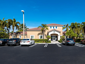 Miami apartment for rent - A building with a parking lot in front of it.