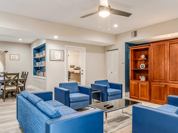 Miami apartment for rent - A living room with blue chairs and a wooden cabinet.