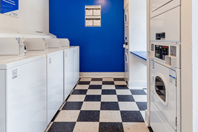 Richmond apartment for rent - a laundry room with white washers and dryers and a blue wall