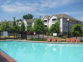 Woodbridge apartment for rent - a swimming pool with apartment buildings in the background at Woodwind Villa, Woodbridge, VA 22191