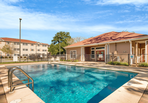Pensacola apartment for rent - our apartments offer a swimming pool with a building in the background