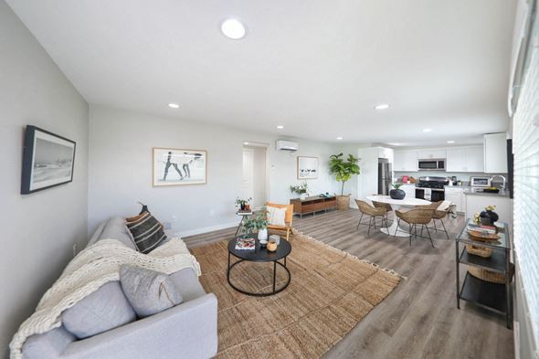 Westminster apartment for rent - a living room with a couch table and chairs and a kitchen in the background