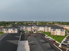 Hugo apartment for rent - A large building with a parking lot in front of it.