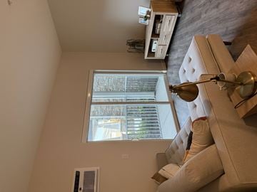 Hugo apartment for rent - A living room with a couch and a window.