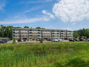 Forest Lake apartment for rent - a large apartment building with cars parked in front of it at Arbor Ridge, Forest Lake, MN, 55025