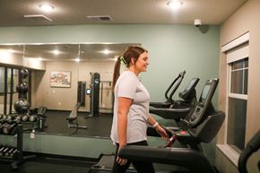 Hugo apartment for rent - A woman is working out on a treadmill in a gym.