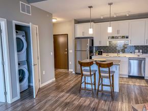 Forest Lake apartment for rent - an open kitchen and dining area with white cabinets and wood floors  at Timber Ridge, Minnesota, 55025