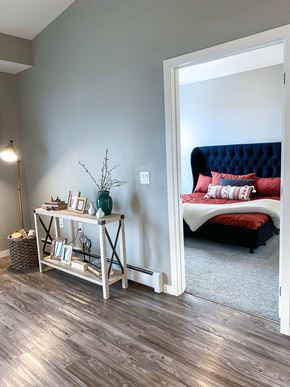 Forest Lake apartment for rent - a bedroom with a bed and a white wall and wood floors  at Timber Ridge, Forest Lake, MN