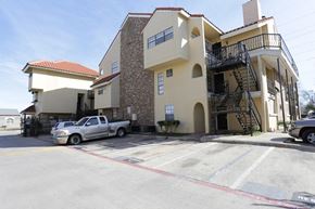 Dallas apartment for rent - A silver truck is parked in front of a two-story building.