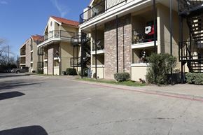 Dallas apartment for rent - Apartment complex with a parking lot in front.