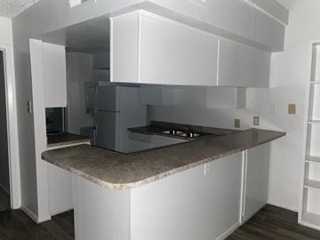 Dallas apartment for rent - A kitchen with white cabinets and a granite countertop.