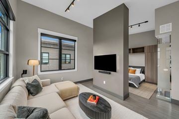 Salt Lake City apartment for rent - A modern living room with a large couch and a flat screen TV.