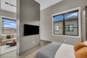 Salt Lake City apartment for rent - A modern bedroom with a large bed and a flat screen TV.