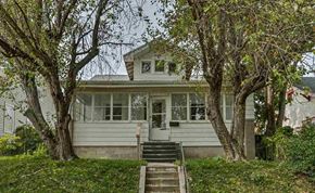Omaha apartment for rent - A house with a front porch and stairs leading up to it.