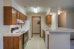 Gretna apartment for rent - A kitchen with white appliances and wooden cabinets.