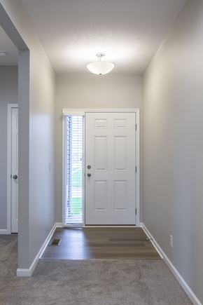 Gretna apartment for rent - A hallway with a white door and carpeted floor.