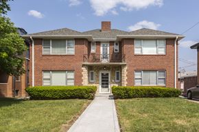 Omaha apartment for rent - A red brick house with a white door and windows.
