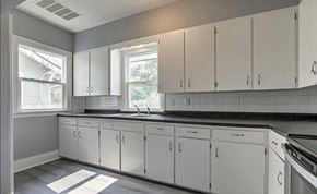 Omaha apartment for rent - A kitchen with white cabinets and a black countertop.