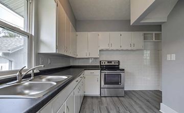 Omaha apartment for rent - A modern kitchen with a stainless steel sink and white cabinets.